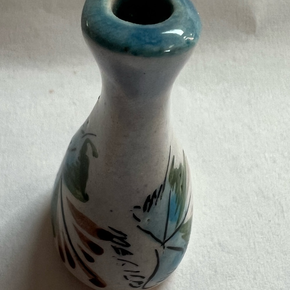 Miniature vintage bud vase. has artwork on three sides.